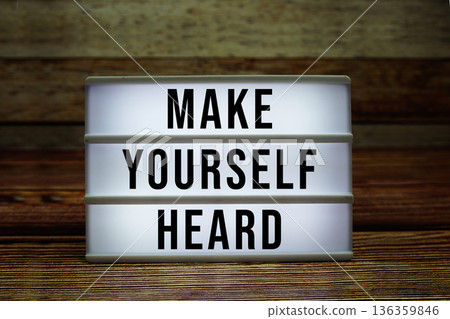 Lightbox with text "Make Yourself Heard" on wooden background 136359846