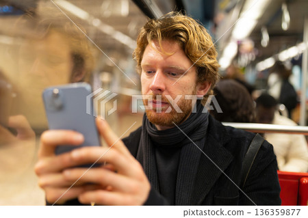 Young man using smartphone inside public transport Young man using smartphone inside public transport 136359877