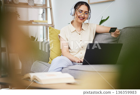 Happy woman, credit card and laptop with headphones in home for ecommerce sales, fintech password and online shopping. Female customer, computer banking and code to upgrade music subscription account 136359983