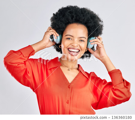 Portrait, black woman and music headphones in studio for podcast, audio and subscription on white background. Face of happy female model listening to album, streaming sound and hearing song on radio Portrait, black woman and music headphones in studio for podcast, audio and subscription on white background. Face of happy female model listening to album, streaming sound and hearing song on radio 136360180