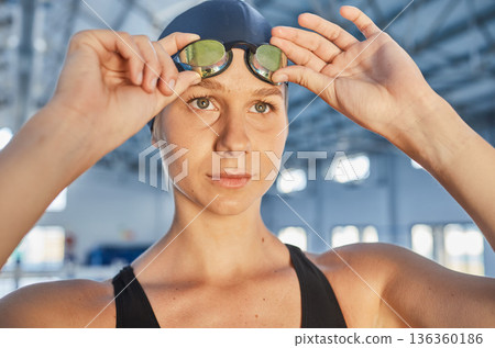 Fitness, thinking and goggles with a woman swimmer getting ready for an event, race or competition in a gym. Sports, exercise and workout with a young female athlete training at a swimming pool Fitness, thinking and goggles with a woman swimmer getting ready for an event, race or competition in a gym. Sports, exercise and workout with a young female athlete training at a swimming pool 136360186