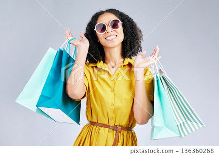 Portrait, sunglasses and woman smile with shopping bag for fashion in studio isolated on a white background. Cool, sales and African customer with gift, discount deal and stylish clothes from store Portrait, sunglasses and woman smile with shopping bag for fashion in studio isolated on a white background. Cool, sales and African customer with gift, discount deal and stylish clothes from store 136360268