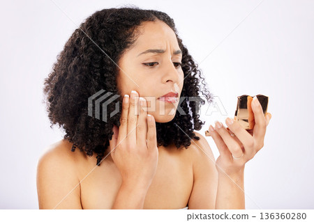 Acne problem, skincare and woman with a mirror for face check, beauty search and inspection for pimple. Sad, wellness and a young girl touching facial skin for health isolated on a studio background Acne problem, skincare and woman with a mirror for face check, beauty search and inspection for pimple. Sad, wellness and a young girl touching facial skin for health isolated on a studio background 136360280