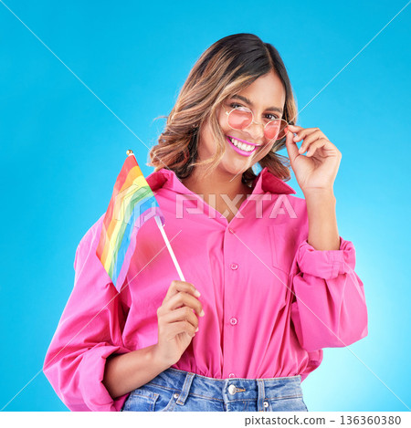 Woman, smile and lgbtq flag in studio portrait with fashion, sunglasses and pride for human rights by blue background. Gen z girl, lesbian student and protest for solidarity, freedom and inclusion Woman, smile and lgbtq flag in studio portrait with fashion, sunglasses and pride for human rights by blue background. Gen z girl, lesbian student and protest for solidarity, freedom and inclusion 136360380