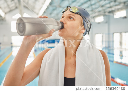 Swimming, woman and drinking water after exercise, training or workout for healthy body. Pool, swim athlete and person with bottle for nutrition, wellness or fitness for liquid hydration after sports Swimming, woman and drinking water after exercise, training or workout for healthy body. Pool, swim athlete and person with bottle for nutrition, wellness or fitness for liquid hydration after sports 136360488