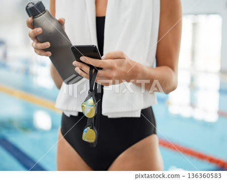 Phone, hands with water and typing at swimming pool for social media. Bottle, swim athlete and woman with smartphone, goggles and internet, website or online sport after workout, training or exercise Phone, hands with water and typing at swimming pool for social media. Bottle, swim athlete and woman with smartphone, goggles and internet, website or online sport after workout, training or exercise 136360583