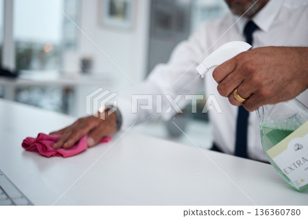 Man, hands and cleaning table in office with cloth, spray bottle and hygiene for safety of virus. Closeup of worker wipe dirty desk, surface and sanitation of dust, disinfection and risk of bacteria Man, hands and cleaning table in office with cloth, spray bottle and hygiene for safety of virus. Closeup of worker wipe dirty desk, surface and sanitation of dust, disinfection and risk of bacteria 136360780