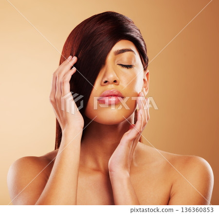 Hair care, beauty and a woman in studio for salon, hairdresser and wellness results. Self care, cosmetics and shampoo for growth and shine of an aesthetic model person on a brown background 136360853