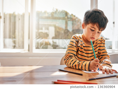 Drawing, education and a child in a house at a table for art, learning writing or creativity. Serious, morning and a kid with paper and color at a desk in a home for knowledge, studying or a picture Drawing, education and a child in a house at a table for art, learning writing or creativity. Serious, morning and a kid with paper and color at a desk in a home for knowledge, studying or a picture 136360904
