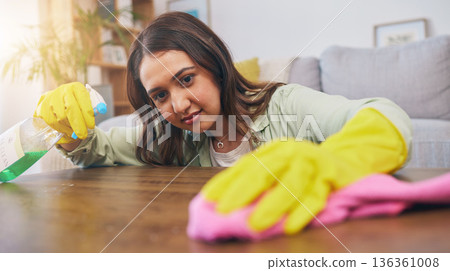 Cleaning table, woman and spray for dust, furniture shine or bacteria on a surface of a house. Smile, working and a girl or cleaner spraying a desk in a living room for housekeeping or home service 136361008