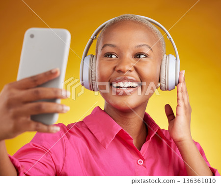 Selfie, smile and black woman with music headphones in studio, streaming or subscription on yellow background. Podcast, profile picture and lady social media influencer online for radio or blog post Selfie, smile and black woman with music headphones in studio, streaming or subscription on yellow background. Podcast, profile picture and lady social media influencer online for radio or blog post 136361010