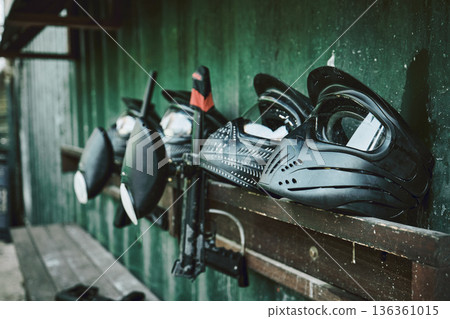 Paintball, helmet and guns on rack at station of sports gear waiting for match, competition or war battle. Paint balling sportswear, weapon or safe equipment on shelf ready for game, fight or warfare Paintball, helmet and guns on rack at station of sports gear waiting for match, competition or war battle. Paint balling sportswear, weapon or safe equipment on shelf ready for game, fight or warfare 136361015