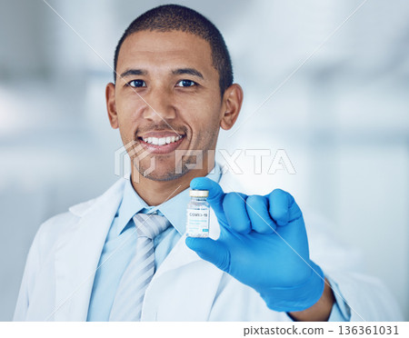 Portrait of man, doctor and vaccine bottle in hand for covid in hospital, safety and pharmaceutical drugs. Healthcare, medicine and medical professional with sample for corona vaccination in clinic. 136361031