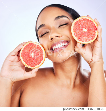 Woman, health and grapefruit for natural beauty, skincare or cosmetics on a studio background. Face of female person with citrus fruit for healthy nutrition, vitamin C or diet and healthcare wellness Woman, health and grapefruit for natural beauty, skincare or cosmetics on a studio background. Face of female person with citrus fruit for healthy nutrition, vitamin C or diet and healthcare wellness 136361036