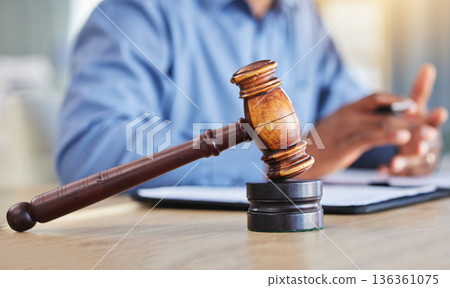 Closeup, lawyer and gavel of judge in office of trial, attention and meeting for justice in courtroom, law firm or table. Hammer, legal tool or attorney working at desk for consulting of constitution Closeup, lawyer and gavel of judge in office of trial, attention and meeting for justice in courtroom, law firm or table. Hammer, legal tool or attorney working at desk for consulting of constitution 136361075