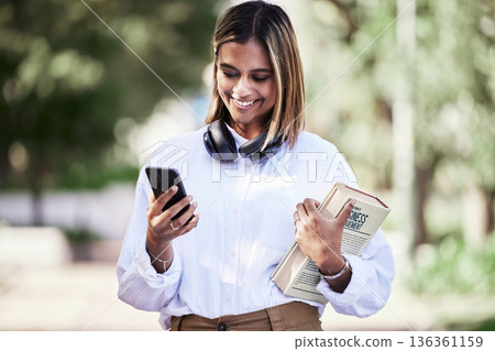 Woman, phone or student with books in park outdoor for communication, music or chat. Social media, research and a happy young female person in campus nature with a smartphone connection and education Woman, phone or student with books in park outdoor for communication, music or chat. Social media, research and a happy young female person in campus nature with a smartphone connection and education 136361159