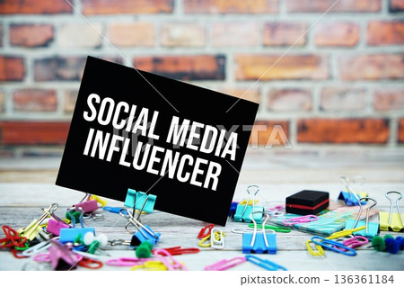 Social Media Influencer text on paper card with stationary on wooden background 136361184