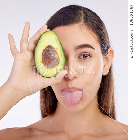 Face, skincare and woman with avocado, tongue out and isolated on a white background in studio. Portrait, beauty and natural model with fruit food for nutrition, healthy diet or omega 3 for wellness Face, skincare and woman with avocado, tongue out and isolated on a white background in studio. Portrait, beauty and natural model with fruit food for nutrition, healthy diet or omega 3 for wellness 136361367