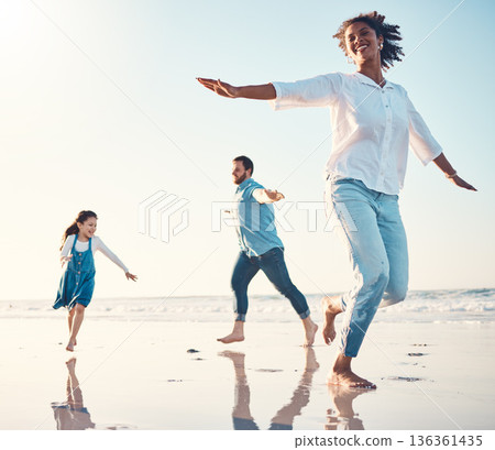 Mother, father and daughter on the beach to dance together while outdoor for travel or vacation in summer. Sunset, family or children and a girl having fun with her parents on the coast by the ocean Mother, father and daughter on the beach to dance together while outdoor for travel or vacation in summer. Sunset, family or children and a girl having fun with her parents on the coast by the ocean 136361435