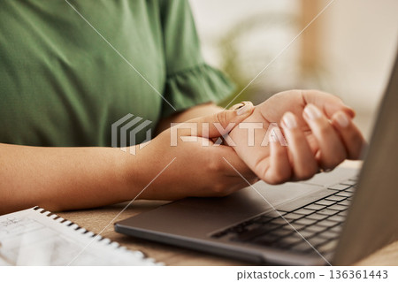 Closeup, laptop and woman with wrist pain, injury and overworked by desk, sprain hand or joint. Female person, entrepreneur or freelancer with a pc, carpal tunnel syndrome or ache with muscle tension 136361443