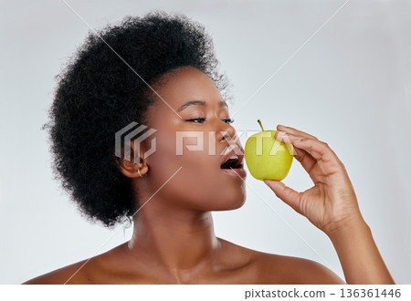 Black woman, hair and apple for natural nutrition, diet or vitamins against a white background in studio. Face of African female person eating organic fruit for healthy wellness, fiber or body care Black woman, hair and apple for natural nutrition, diet or vitamins against a white background in studio. Face of African female person eating organic fruit for healthy wellness, fiber or body care 136361446