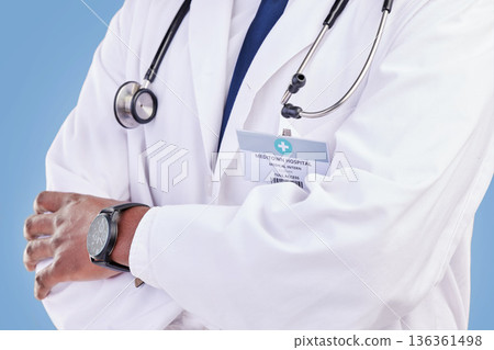 Doctor, stethoscope and arms crossed in studio with a medical expert or healthcare worker on blue background. Surgeon, hands and confidence in medicine or pharmaceutical research in hospital 136361498