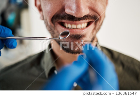 Smile, man and hands of dentist with tools for dental, healthcare or check in clinic. Tooth wellness, orthodontics and patient with doctor, mirror and excavator for teeth cleaning and medical hygiene 136361547