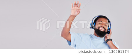 Headphones, mockup and young man in a studio listening to music, playlist or album while dancing. Happy, smile and African male model streaming a song or radio by a gray background with mock up space Headphones, mockup and young man in a studio listening to music, playlist or album while dancing. Happy, smile and African male model streaming a song or radio by a gray background with mock up space 136361574