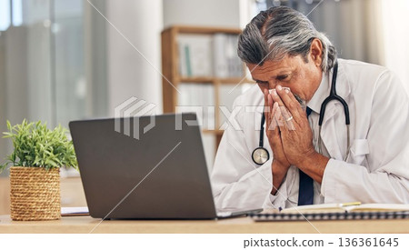 Sneezing, sick and a doctor with a laptop in an office, blowing nose and an allergy at a hospital. Healthcare, medicine and a mature medical employee with a tissue with covid or a virus at work Sneezing, sick and a doctor with a laptop in an office, blowing nose and an allergy at a hospital. Healthcare, medicine and a mature medical employee with a tissue with covid or a virus at work 136361645