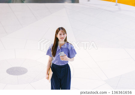 Young woman standing on the lobby floor 136361656