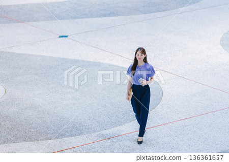 Young woman standing on the lobby floor 136361657