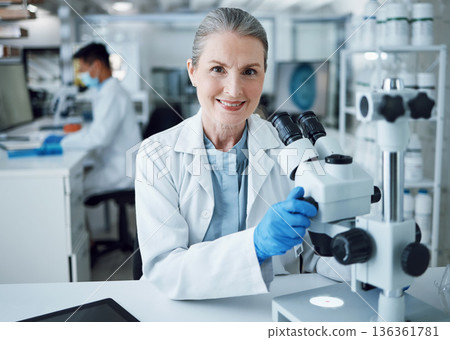 Microscope, scientist and portrait of senior woman in laboratory to review virus research, medical test and biotechnology. Science, microbiology and happy female professor planning expert assessment Microscope, scientist and portrait of senior woman in laboratory to review virus research, medical test and biotechnology. Science, microbiology and happy female professor planning expert assessment 136361781