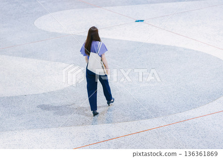 年輕女子站在大廳地板上 136361869