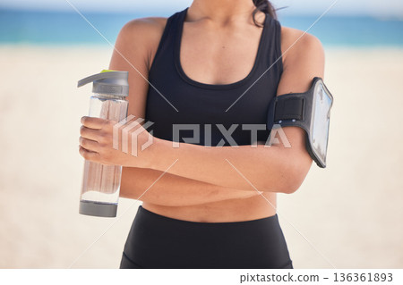 Woman, fitness and water with arms crossed on beach for workout, exercise or natural outdoor nutrition. Hands of female person with bottle of mineral liquid for running, training or healthy wellness Woman, fitness and water with arms crossed on beach for workout, exercise or natural outdoor nutrition. Hands of female person with bottle of mineral liquid for running, training or healthy wellness 136361893
