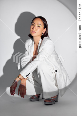 Serious, portrait and fashion with spotlight on woman in studio for makeup, creative and art. Design, glamour and luxury with face of person on white background for cosmetics, trendy and beauty 136362126