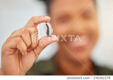 Hearing aid, hands and person with disability for medical support, listening or healthcare innovation. Closeup of deaf patient with audiology implant, amplifier tech or accessory to help sound waves 136362279