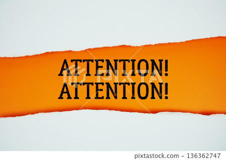 Attention! Attention! text on orange with white paper torn ripped of horizontal Attention! Attention! text on orange with white paper torn ripped of horizontal 136362747