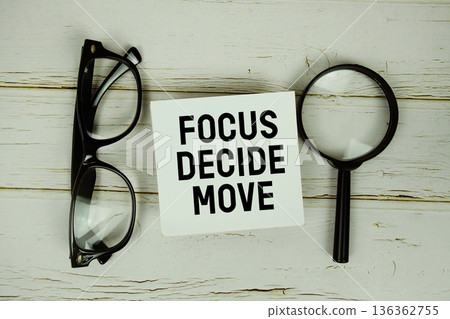 Focus Decide Move text with eye glasses and magnifying glass on wooden background 136362755