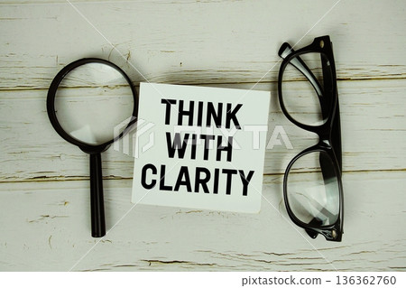Think With Clarity text with eye glasses and magnifying glass on wooden background 136362760