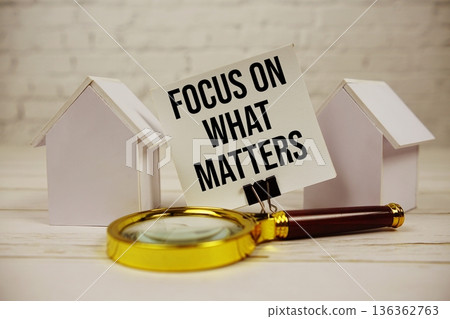 Focus On What Matters with magnifying glass and house model on wooden background Focus On What Matters with magnifying glass and house model on wooden background 136362763