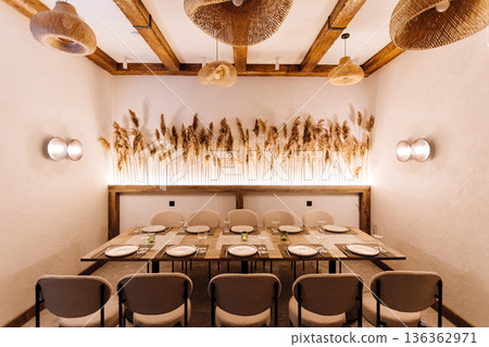 Cozy private dining room with rattan pendants and pampas decor, set table 136362971