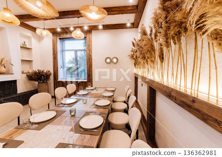 Boho private dining room set for dinner with rattan lamps and pampas wall 136362981