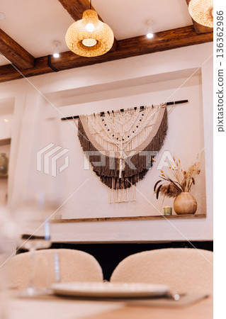 Boho fireplace mantel with macrame wall hanging, candles and dried flowers 136362986