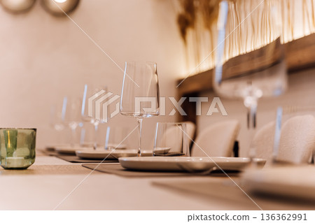 Elegant restaurant table setting with wine glasses and warm boho ambiance Elegant restaurant table setting with wine glasses and warm boho ambiance 136362991