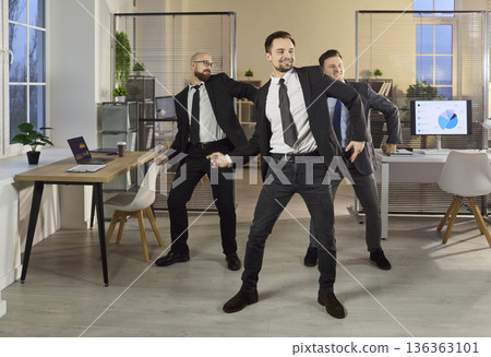 Office team of businessmen dancing, celebrating success and positive energy Office team of businessmen dancing, celebrating success and positive energy 136363101