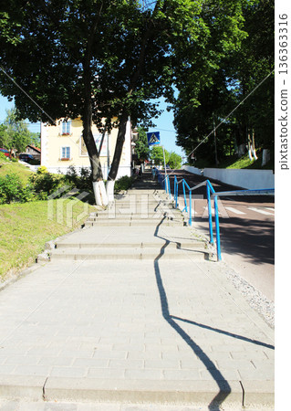 staircase on a sunny day between trees with railings 136363316