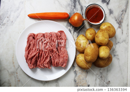 Products for making potato pancakes, sorcerers, meat, potatoes, carrots, onions, seasoning, top view Products for making potato pancakes, sorcerers, meat, potatoes, carrots, onions, seasoning, top view 136363394