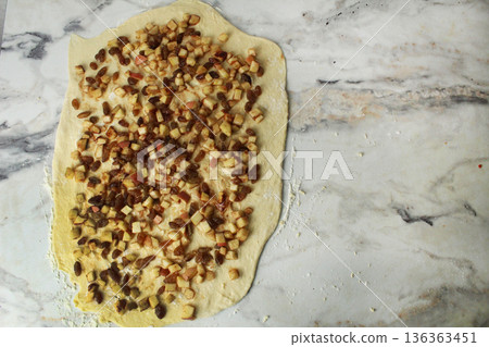 Cooking buns. Bun filling on rolled dough with apples and raisins 136363451