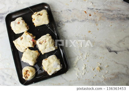 Raw buns on a black baking sheet top view place for eksta copyspace 136363453