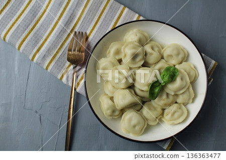 Dumplings on a plate, serving dinner, dumplings with filling. Homemade dishes: top view Dumplings on a plate, serving dinner, dumplings with filling. Homemade dishes: top view 136363477